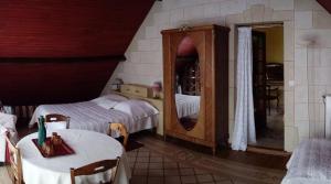 a bedroom with two beds and a mirror at La Maison du Verger in Acquigny