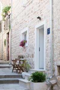 a brick building with a table and a door with flowers at Agata House Hvar in Hvar