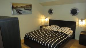 una camera da letto con un letto con un piumone a righe in bianco e nero di Bed in Boat a Ypres