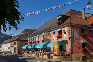 a street in a town with buildings and flags at Hotel de la Poste in Corps