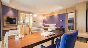 ein Hotelzimmer mit einem Schreibtisch, einem Bett und einem Schlafzimmer in der Unterkunft James Joyce Coffetel Chengdu Jichang Road Shenxianshu in Chengdu + 215 Fotos