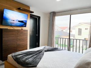 a bedroom with a bed and a tv and a window at Casa de 3 Dormitorios con Piscina Privada, BBQ y Seguridad in Estancia Vieja +23 photos