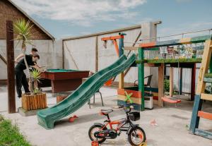 a man standing next to a playground with a slide at Casa Ilinca in Filioara