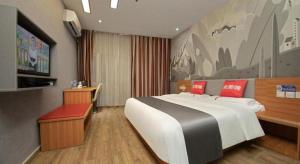 a bedroom with a large bed and a painting on the wall at Thank Inn Plus Hotel Zhuhai Nanping pedestrian Street Huafa shopping Center in Zhuhai