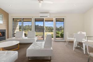 a living room with white furniture and a fireplace at H Boutique Hotel in Pokolbin