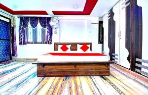 ein Schlafzimmer mit einem großen Bett mit roten Kissen in der Unterkunft Hill view resort in Jaipur