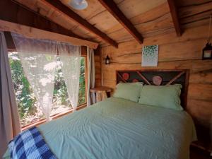 een slaapkamer met een bed in een blokhut bij Tipi Bribri in Heredia +12 foto's