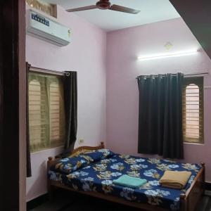 a bedroom with a bed and a ceiling fan at Garden Villa, Hyderabad in Hyderabad