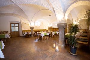 un restaurante con mesas y sillas y techo blanco en Fischhof Beer en Mitterteich