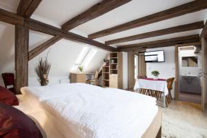 Un dormitorio con una gran cama blanca y una mesa en Fischhof Beer, en Mitterteich