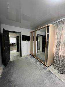 ein Wohnzimmer mit einem großen Spiegel und einem TV in der Unterkunft 1-Confortable and ideal Apartament-Квартира посуточно Edinet in Edineţ