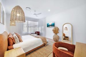 a bedroom with a large bed and a chair at Cinema Pool Pets 4b2b Bargara Headlands in Pemberton +49 photos
