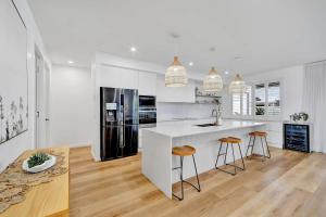 a kitchen with a white counter and a black refrigerator at Cinema Pool Pets 4b2b Bargara Headlands in Pemberton