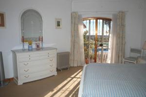 a bedroom with a bed and a dresser with a mirror at Genies Villa Boutique Algarve in Almancil