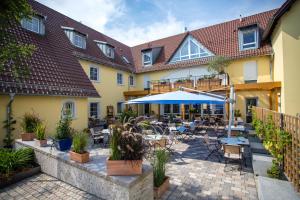 Das Crass في Nieder-Olm: ساحة فندق فيها طاولات وكراسي