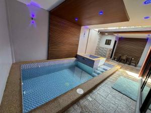 a large swimming pool in a room with at Luxury Oasis Pool Villa in Sampong