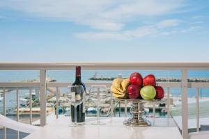 a table with a plate of fruit and a bottle of wine at Protea's Seacret Sea View Studios in Paralia Katerinis