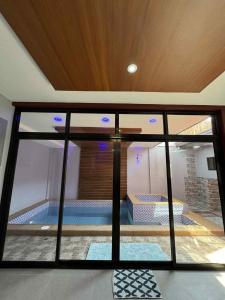 a view of a swimming pool through a glass window at Luxury Oasis Pool Villa in Sampong