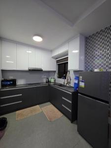 a kitchen with black and white cabinets and a refrigerator at Luxury Oasis Pool Villa in Sampong