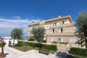 a large building with a bench in front of it at Residence Levante in Misano Adriatico