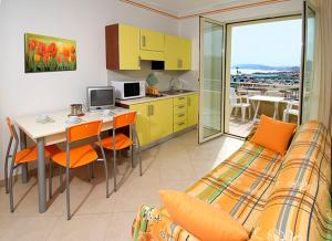 a living room with a couch and a kitchen with a table at Residence Levante in Misano Adriatico