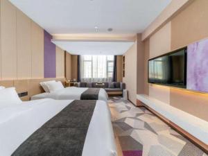 潮州市にあるLavande Hotel Chaozhou Fortune Center Lin Streetのベッド2台と薄型テレビ付きのホテルの部屋