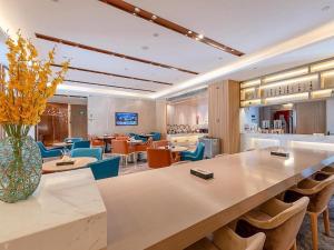 hol z dużym stołem i krzesłami w obiekcie Lavande Hotel Zhongshan Shiqi Daxinxinduhui North Zhongshan Station w mieście Zhongshan