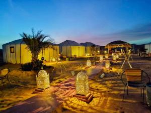 a group of sculptures in a desert at night at Merzouga Luxury Camp in Merzouga