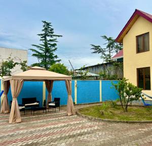 a patio with an umbrella and chairs next to a building at Royal Cottage in Ureki
