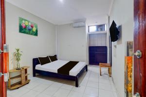 a small bedroom with a bed in a room at Collection O Bali near Beachwalk Shopping Center formerly Budget Door Legian Inn in Legian