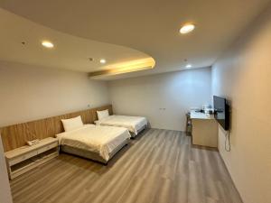 Posteľ alebo postele v izbe v ubytovaní Xingyi Hotel