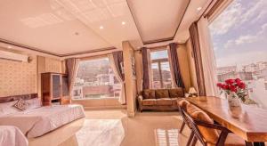 SU SU HOTEL QUY NHƠN في كوي نون: غرفة نوم مع مكتب وسرير وطاولة