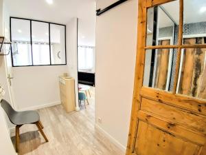 a room with a wooden door and a chair at Une halte, Proche Notre-Dame in Rodez