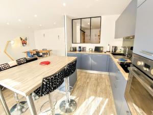 a kitchen with a wooden table and some chairs at Une halte, Proche Notre-Dame in Rodez