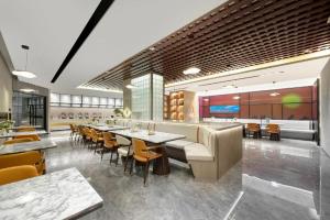 a restaurant with tables and chairs and a bar at Atour Hotel Urumqi Municipal Government Nanhu People's Square in Ürümqi