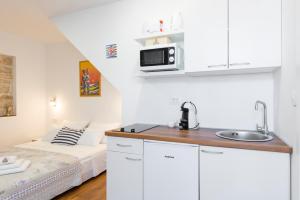 una cocina con fregadero y una cama en una habitación en Agata House Hvar, en Hvar