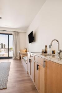 a kitchen with a sink and a living room at Offshore Montauk in Montauk