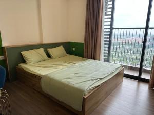 un letto in una camera con una grande finestra di Chích Cún Homestay Sky Oasis Ecopark a Kim Quan