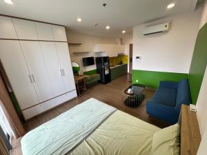 un soggiorno con un divano blu e una cucina di Chích Cún Homestay Sky Oasis Ecopark a Kim Quan