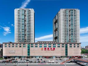 two tall white buildings in a city with a parking lot at Y.TUO Hotel Universal Beijing Resort in Liyuanzhen