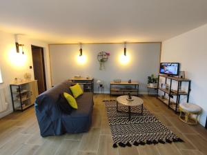 un salon avec un canapé bleu et une télévision dans l'établissement Gîte L'Ermitage des Pré'O, à Neuvy-Grandchamp