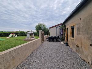 une allée menant à une cour arrière avec une aire de jeux dans l'établissement Gîte L'Ermitage des Pré'O, à Neuvy-Grandchamp