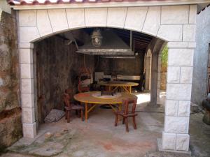 an outdoor kitchen with a table and chairs in an archway at Room Rade in Stari Grad
