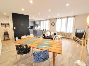 a living room with a wooden table and a living room at Une halte, Proche Notre-Dame in Rodez