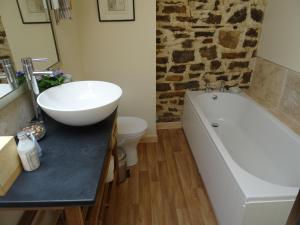 a white bath tub sitting next to a white sink at Hollamoor Farm in Barnstaple