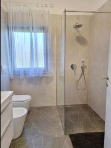 une salle de bain avec douche et toilettes et une fenêtre dans l'établissement App Meri, à Savudrija 18 autres photos