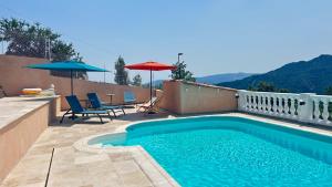 a swimming pool with chairs and umbrellas on a patio at Chambres d'hôtes Les Nymphéas in Revest-les-Roches