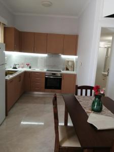 a kitchen with a dining table and a kitchen with a stove at evia mourteri Apartment in Mourteri +11 photos