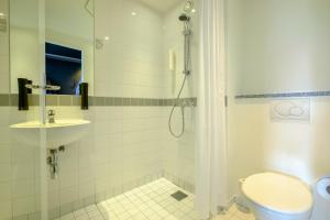 a bathroom with a shower and a toilet and a sink at Zleep Hotel Ballerup in Ballerup