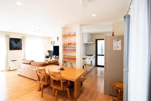 a dining room and living room with a wooden table at 福の荘 唐人 in Fukuoka